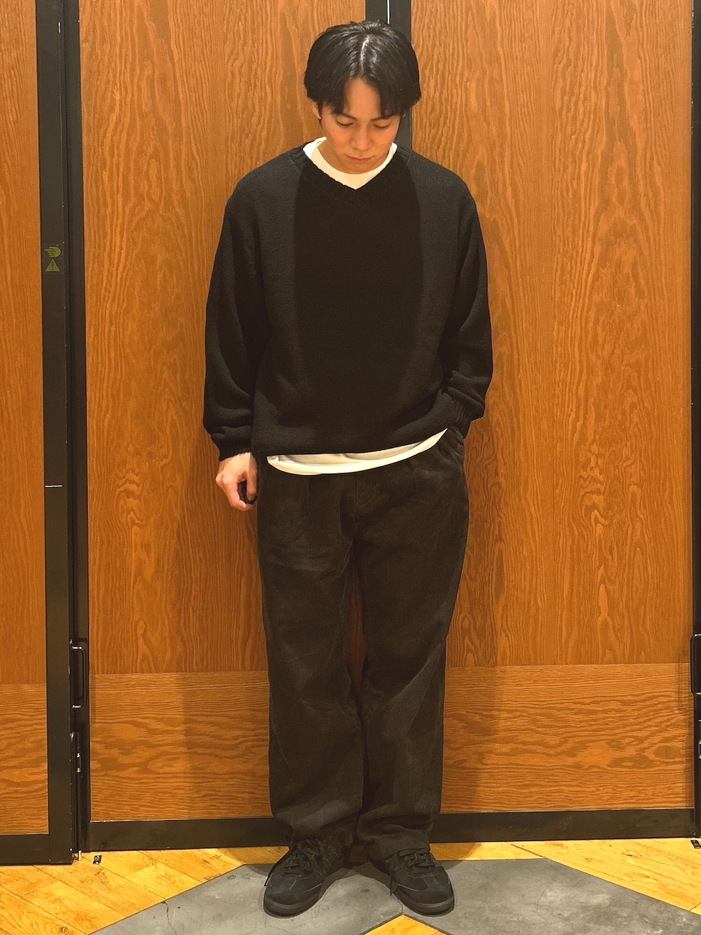 ブラック系のニット/セーター、グレー系のその他パンツ、ブラック系のスニーカーを着用したメンズの秋コーディネートの1枚目の写真