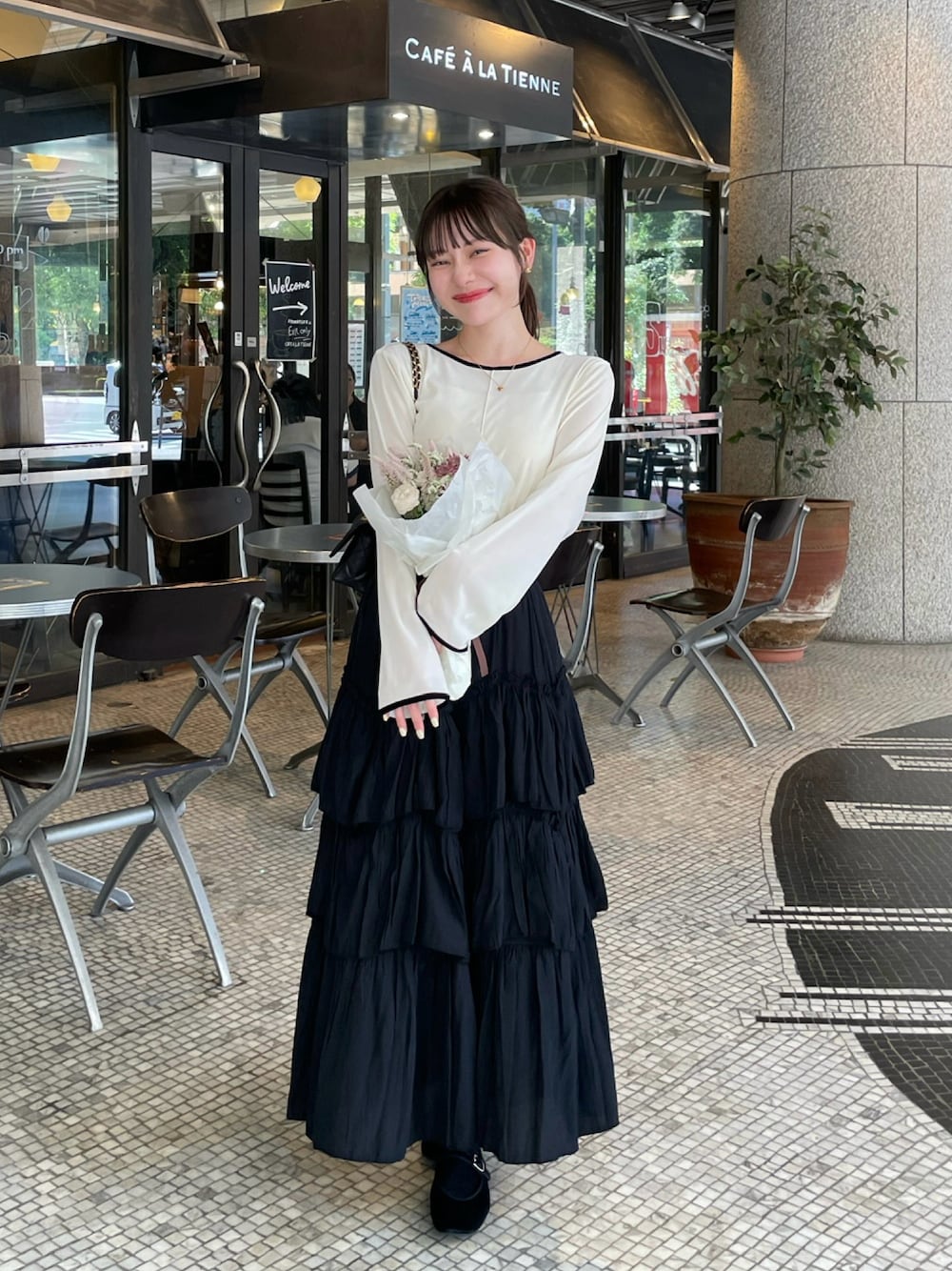 ブラック系のスカート、ホワイト系のTシャツ/カットソー、ホワイト系のTシャツ/カットソーを着用したレディースの秋コーディネートの1枚目の写真