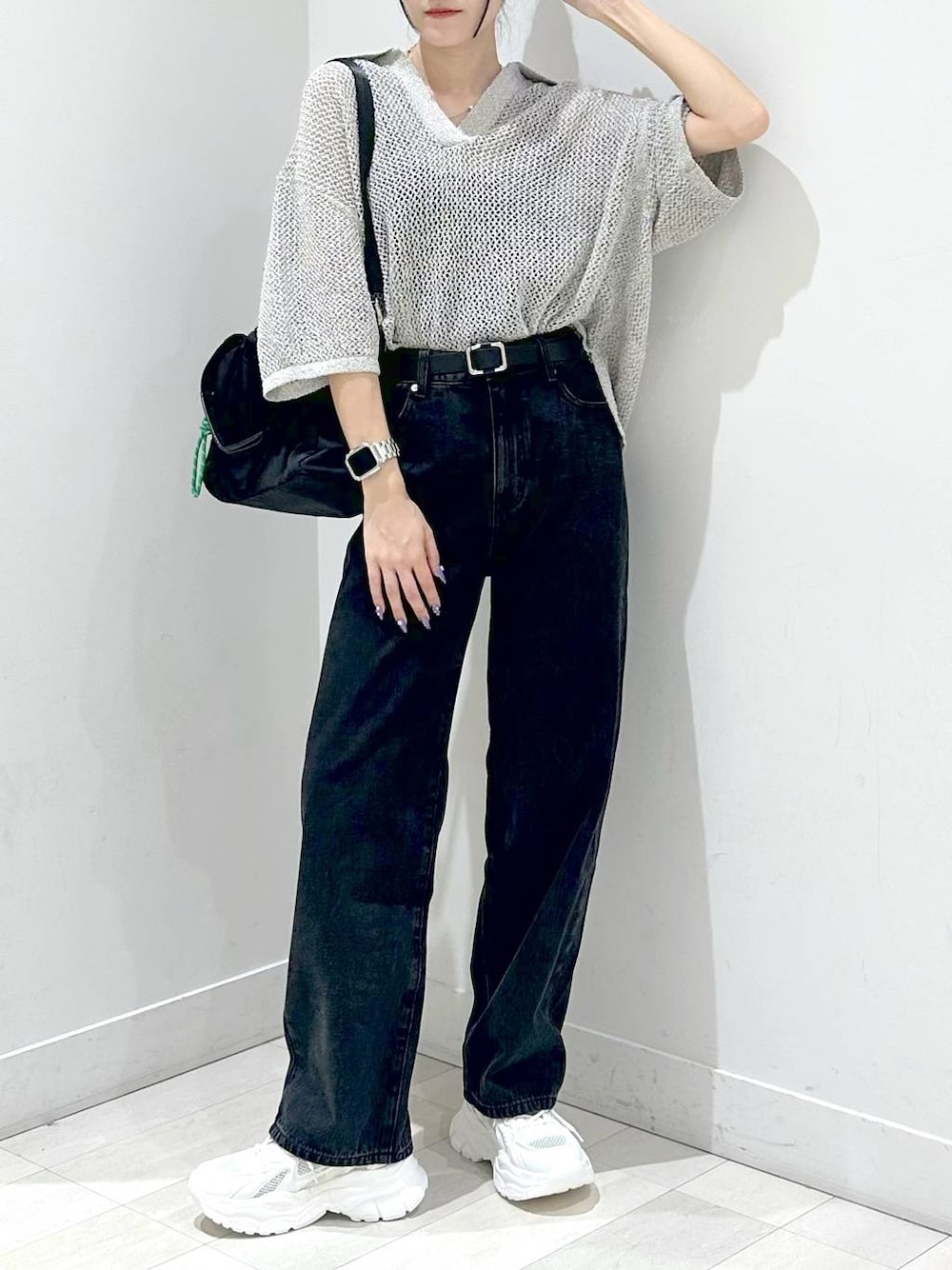 ブラック系のトートバッグ、ブラック系のデニムパンツ、ホワイト系のスニーカーを着用したレディースの秋コーディネートの1枚目の写真