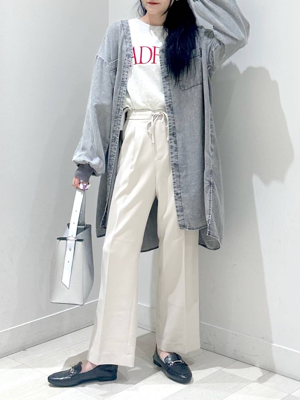 ブラック系のローファー、シルバー系のショルダーバッグ、ベージュ系のスラックスを着用したレディースの秋コーディネートの1枚目の写真