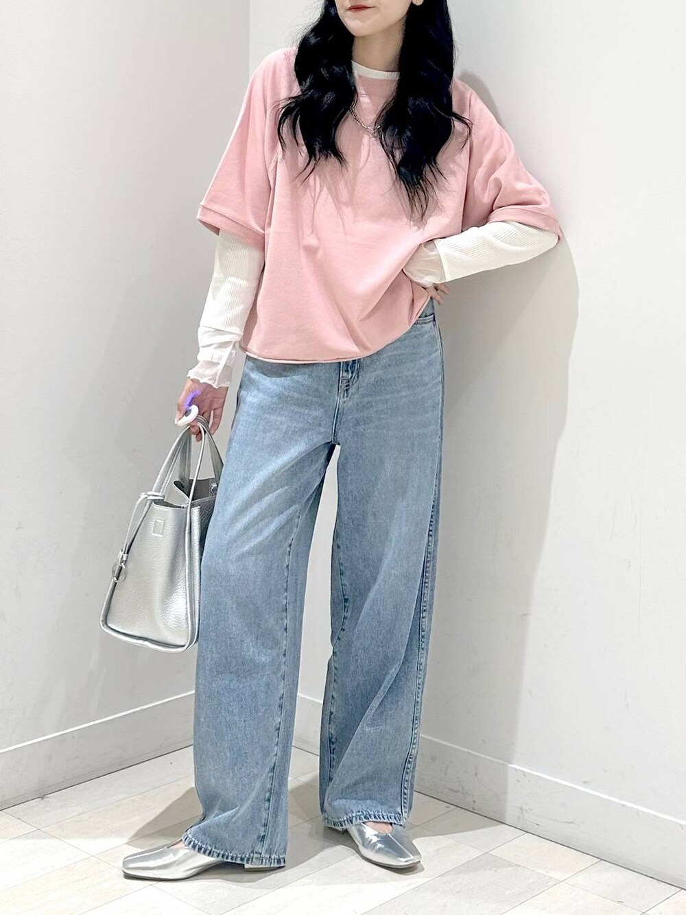ブルー系のデニムパンツ、ピンク系のTシャツ/カットソー、シルバー系のトートバッグを着用したレディースの秋コーディネートの1枚目の写真