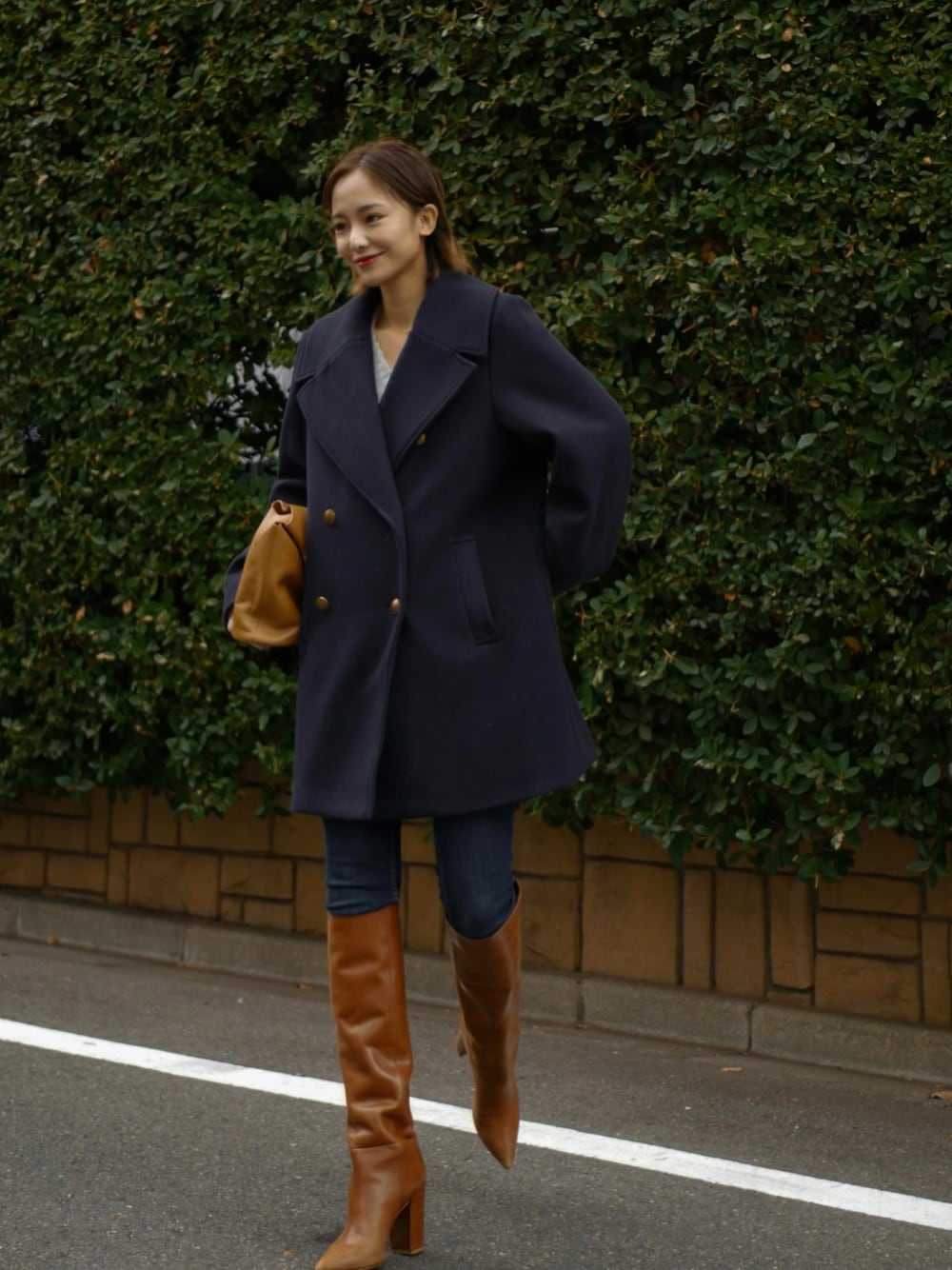 ブルー系のピーコート、イエロー系のハンドバッグを着用したレディースの秋コーディネートの1枚目の写真