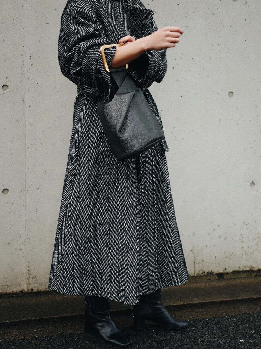 ブラック系のハンドバッグを着用したレディースの冬コーディネートの1枚目の写真