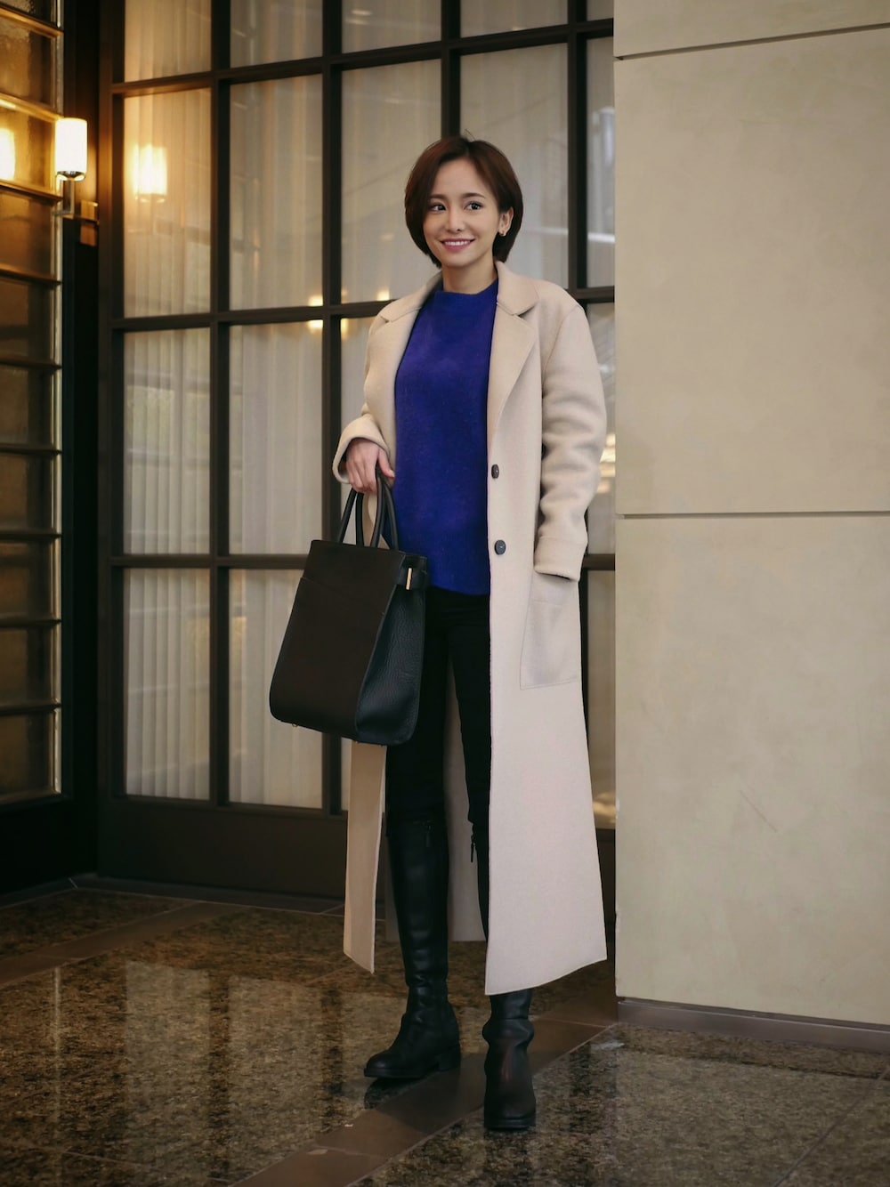 ブラック系のハンドバッグを着用したレディースの冬コーディネートの1枚目の写真