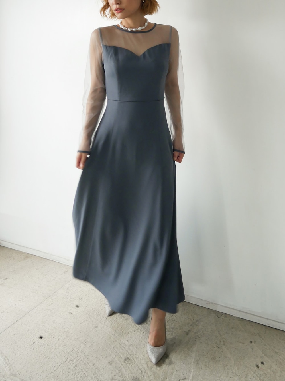 ブルー系のドレス、ホワイト系のネックレスを着用したレディースの夏コーディネートの1枚目の写真