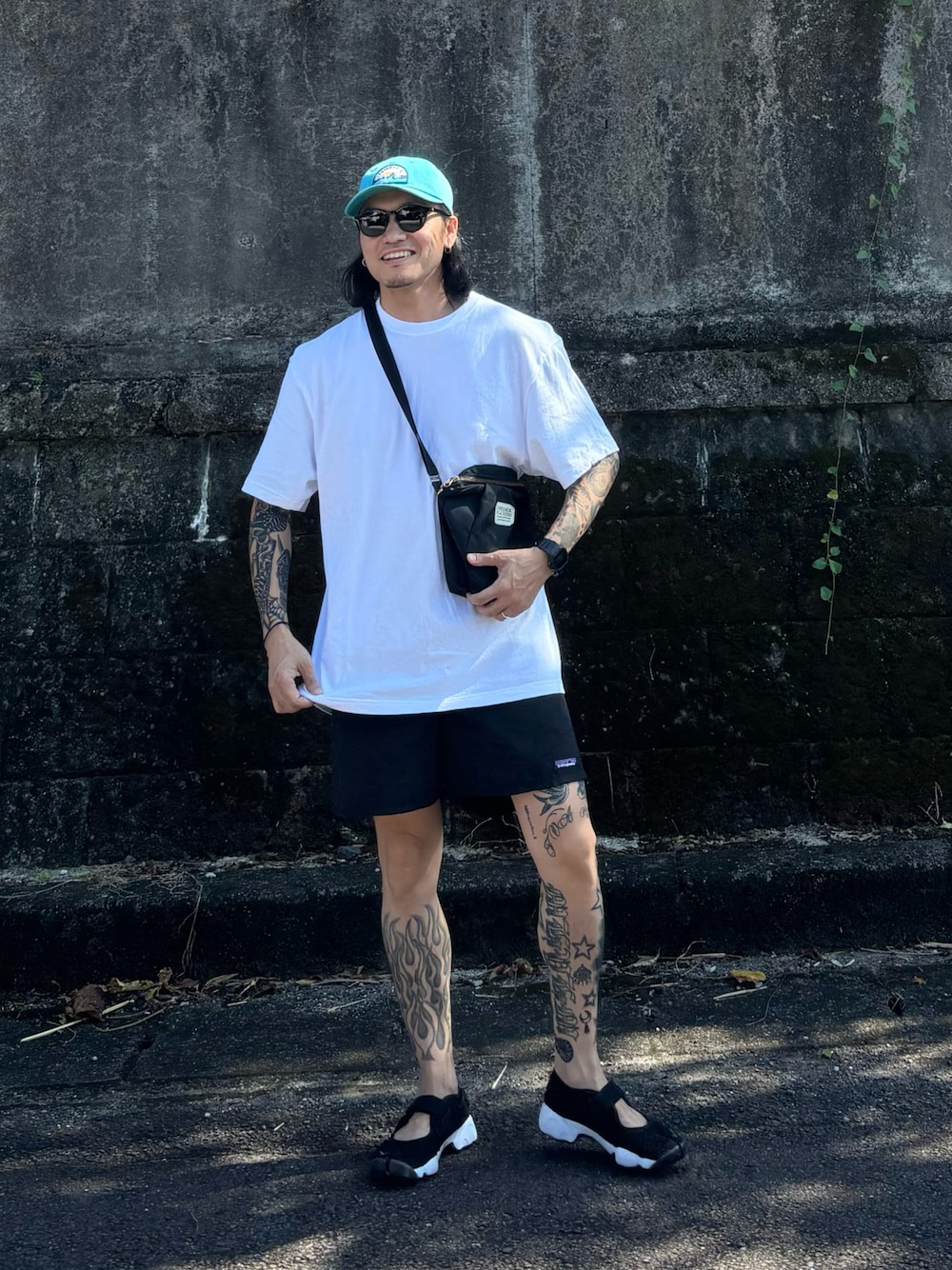 ブラック系のボディバッグ/ウエストポーチ、ブラック系のサンダル、ブラック系のその他パンツを着用したメンズの夏コーディネートの1枚目の写真