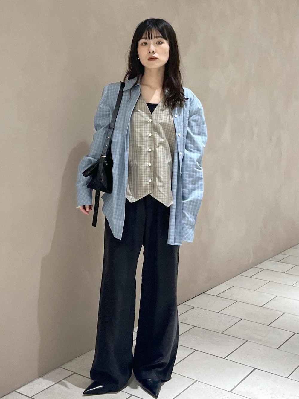 ブラック系のその他パンツ、ブラック系のショルダーバッグ、ブルー系のシャツ/ブラウスを着用したレディースの秋コーディネートの1枚目の写真