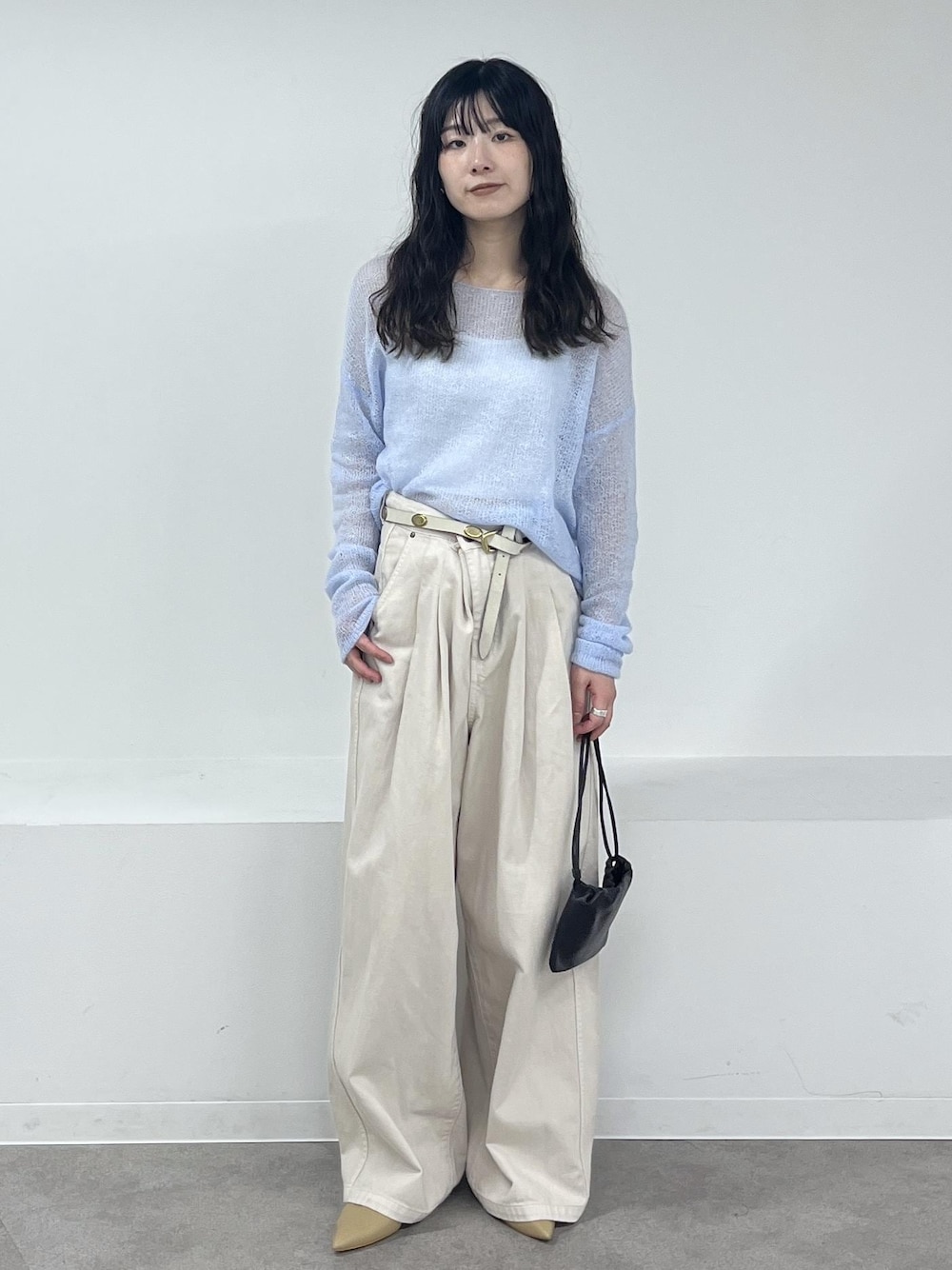 ホワイト系のデニムパンツ、ブルー系のニット/セーター、ベージュ系のパンプスを着用したレディースの冬コーディネートの1枚目の写真