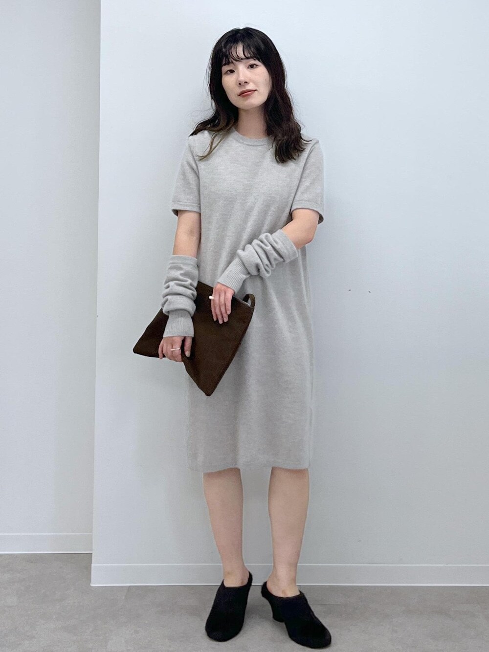 ブラウン系のショルダーバッグ、ベージュ系のワンピース、ブラック系のその他シューズを着用したレディースの秋コーディネートの1枚目の写真