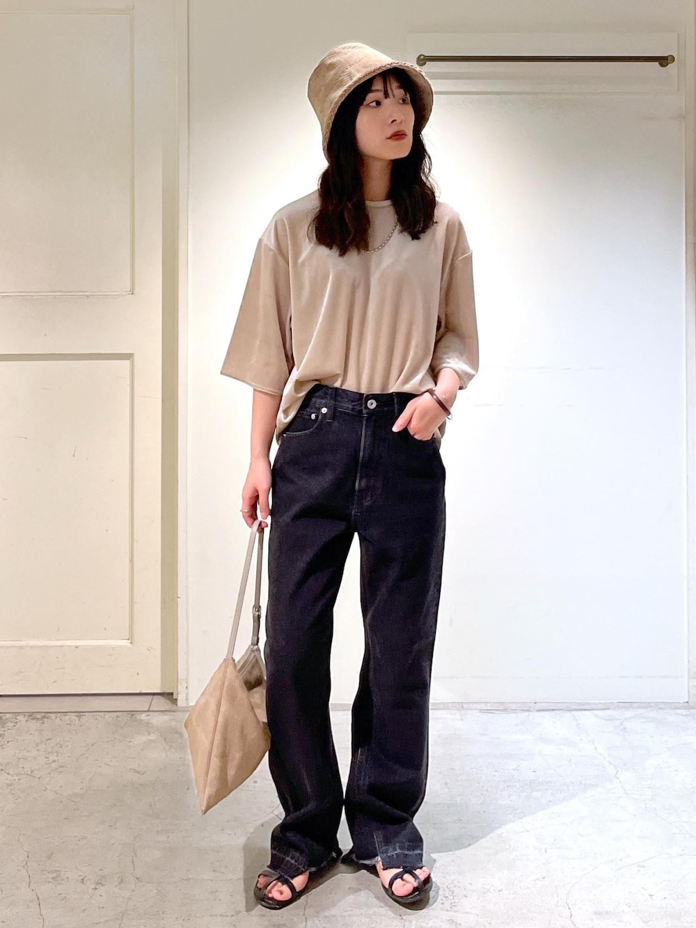 ブラック系のサンダル、グレー系のデニムパンツ、ベージュ系のTシャツ/カットソーを着用したレディースの夏コーディネートの1枚目の写真