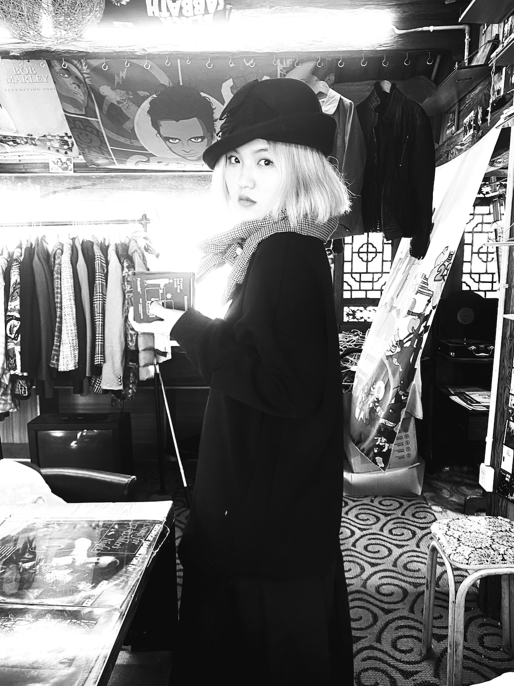 ブラック系のワンピース、ブラック系のキャップ、ブラウン系のマフラーを着用したレディースの冬コーディネートの1枚目の写真