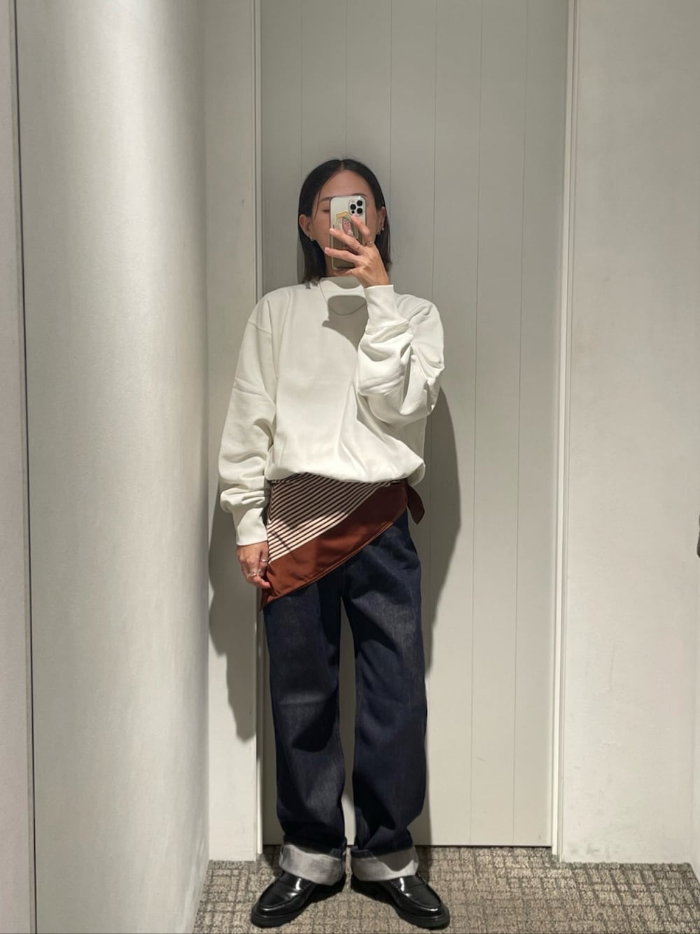 ホワイト系のスウェット、ブルー系のデニムパンツ、ブラウン系のバンダナ/スカーフを着用したレディースの秋コーディネートの1枚目の写真