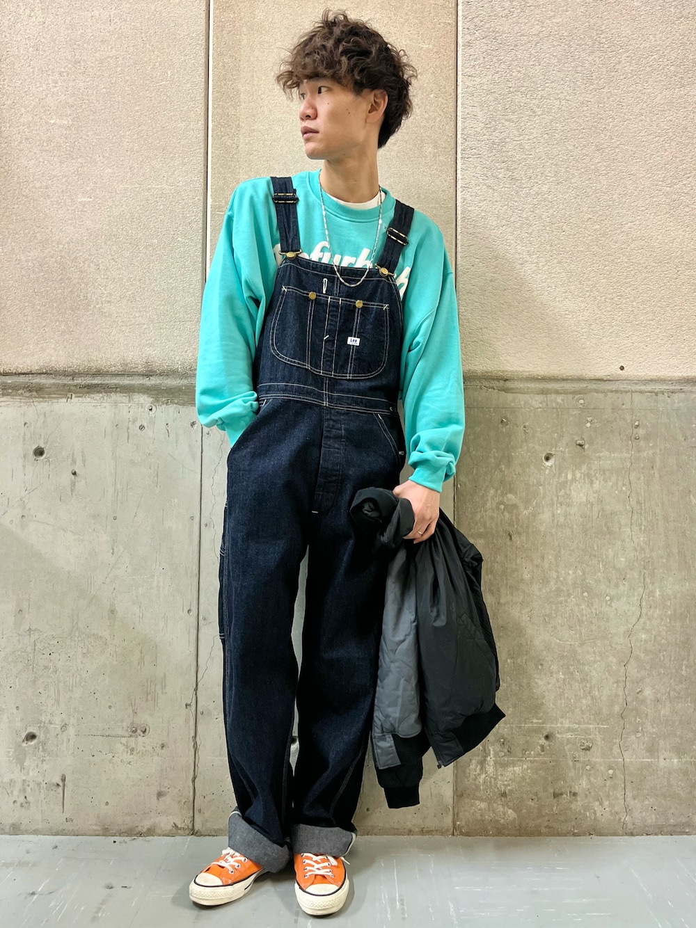 オレンジ系のスニーカー、ブルー系のサロペット/オーバーオール、ブルー系のスウェットを着用したメンズの冬コーディネートの1枚目の写真