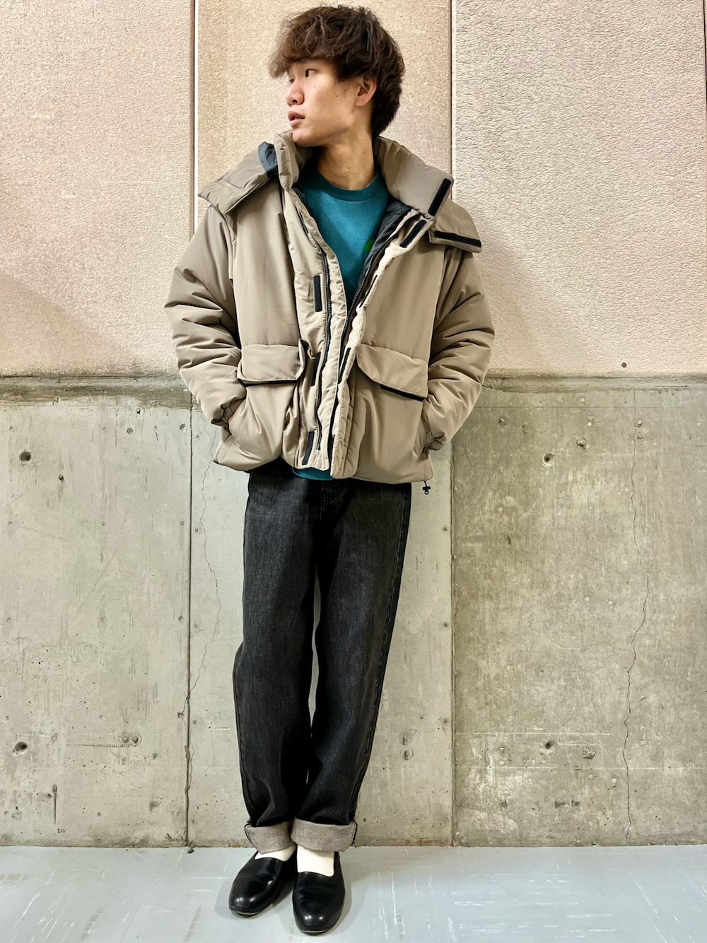 ブラック系のデニムパンツ、ベージュ系のダウンジャケット/コート、グリーン系のスウェットを着用したメンズの秋コーディネートの1枚目の写真