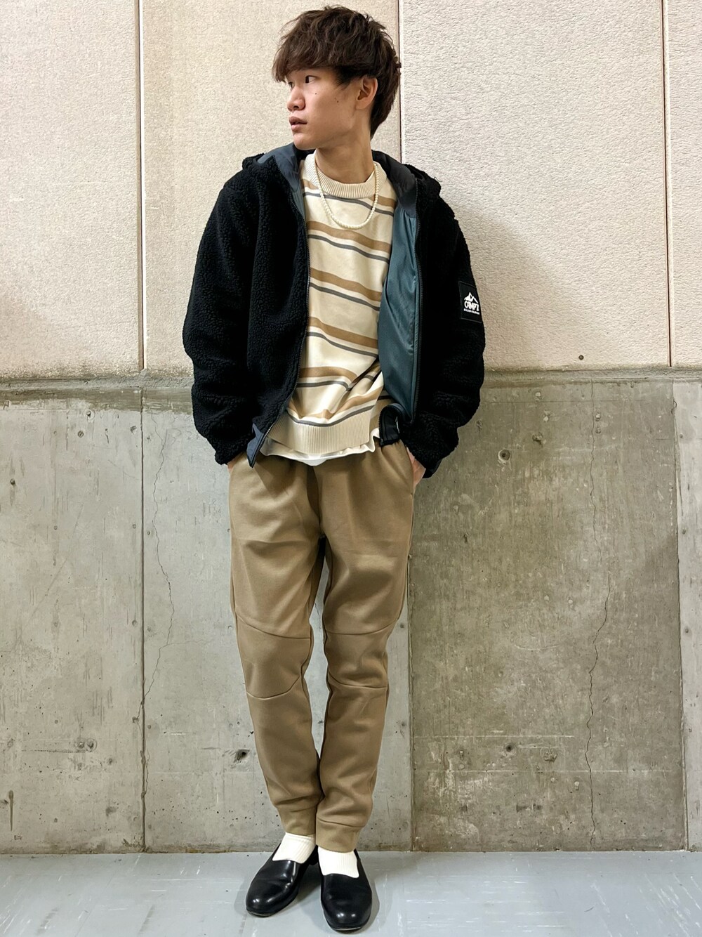 ベージュ系のその他パンツ、ホワイト系のニット/セーター、ブラック系のブルゾンを着用したメンズの秋コーディネートの1枚目の写真