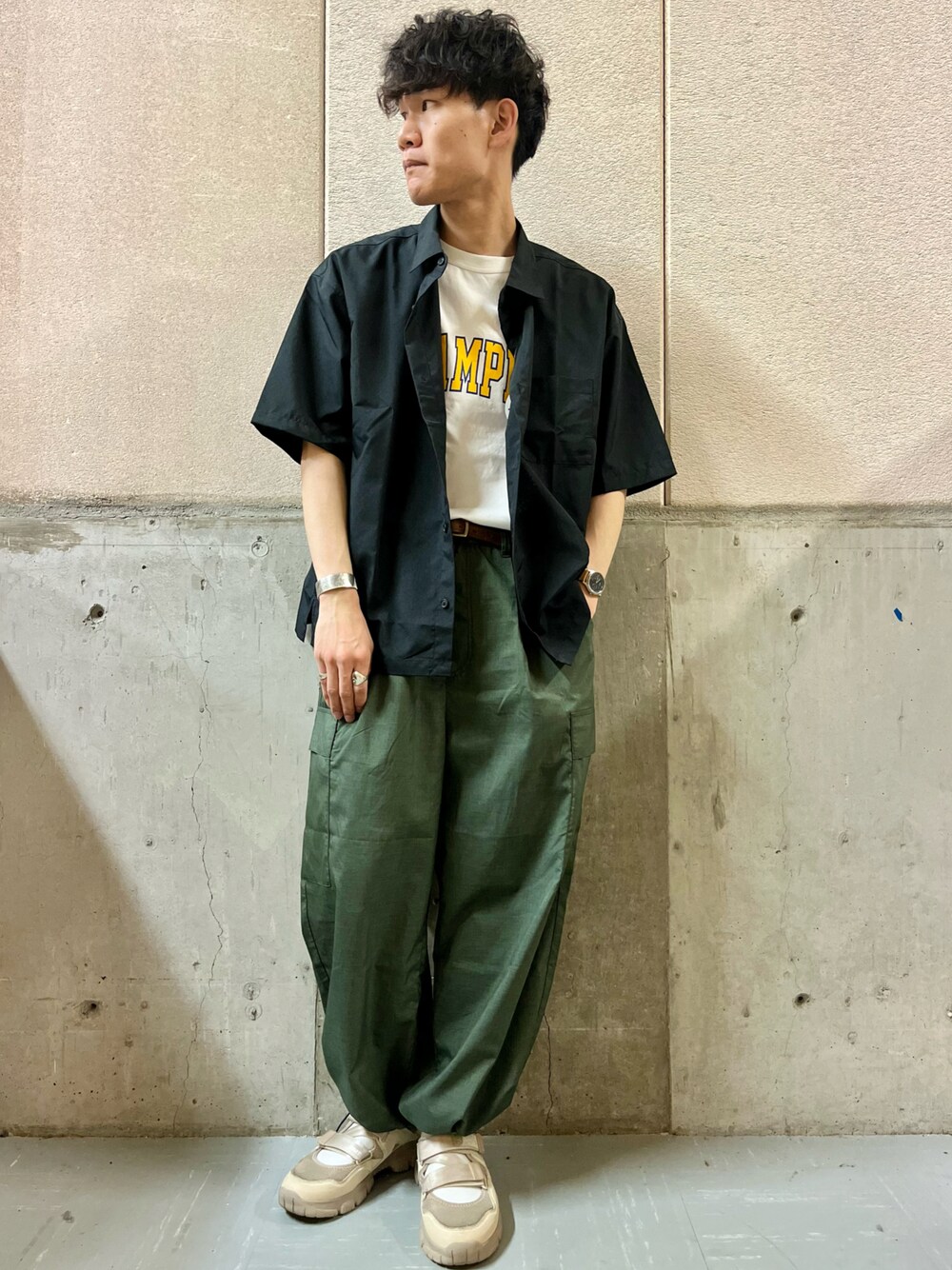 グリーン系のカーゴパンツ、ベージュ系のスニーカー、ブラック系のシャツ/ブラウスを着用したメンズの夏コーディネートの1枚目の写真