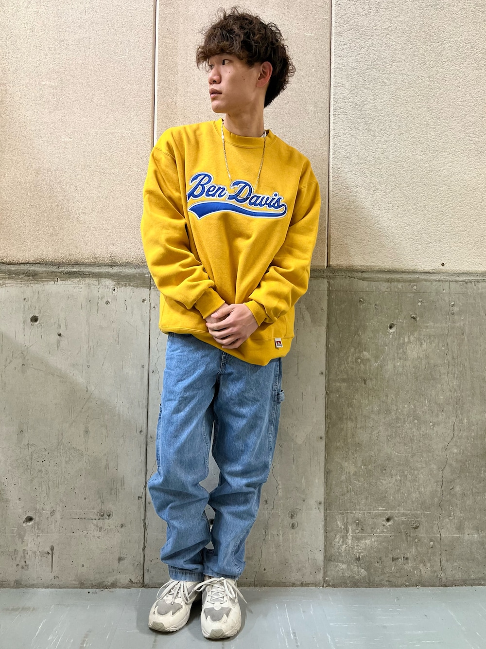 ブルー系のデニムパンツ、イエロー系のスウェット、ホワイト系のスニーカーを着用したメンズの冬コーディネートの1枚目の写真