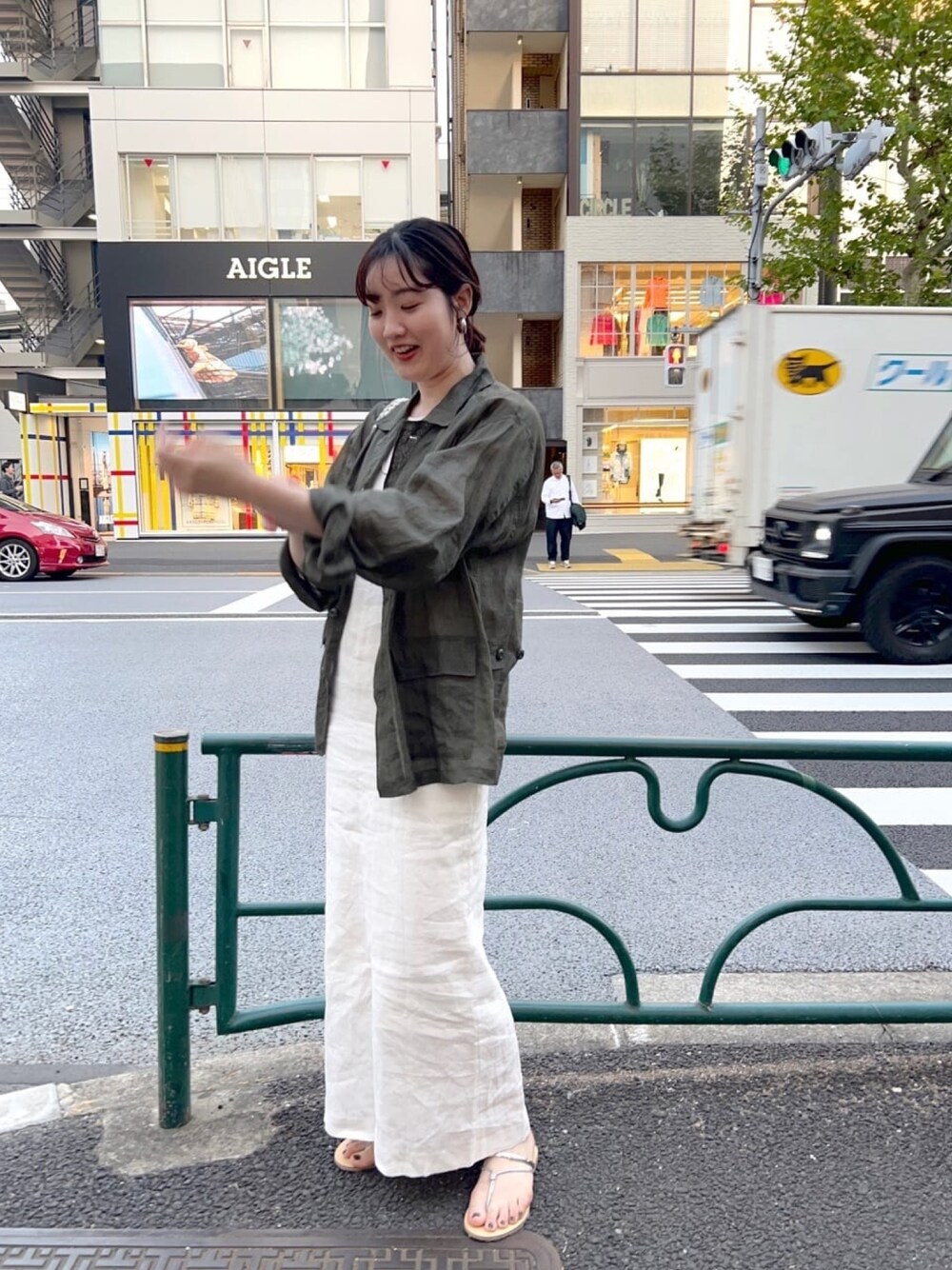 グリーン系のジャケット/アウター、ホワイト系のワンピース、ゴールド系のサンダルを着用したレディースの春コーディネートの1枚目の写真