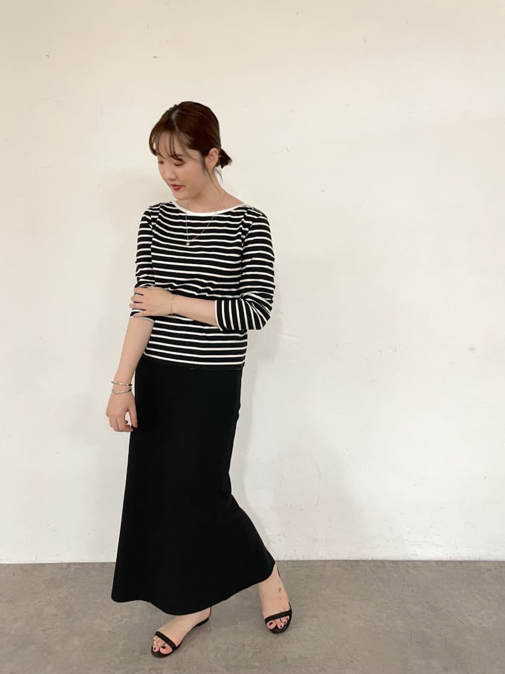 ブラック系のTシャツ/カットソー、ブラック系のスカート、ブラック系のサンダルを着用したレディースの夏コーディネートの1枚目の写真