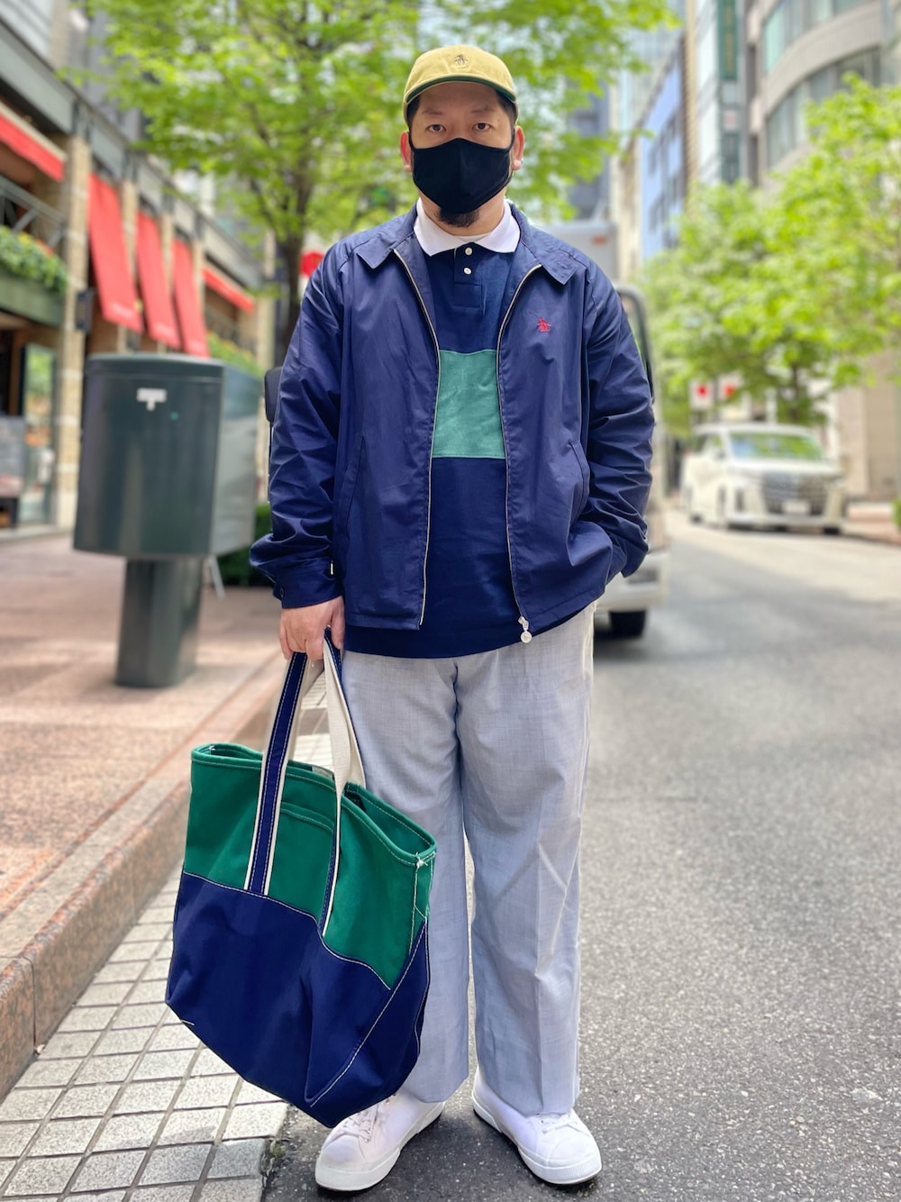 ブルー系のポロシャツ、ブルー系のブルゾン、グレー系のスラックスを着用したメンズの春コーディネートの1枚目の写真