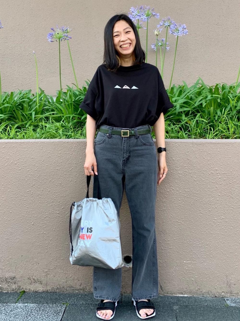 ブラック系のデニムパンツ、シルバー系のトートバッグ、ブラック系のTシャツ/カットソーを着用したレディースの夏コーディネートの1枚目の写真