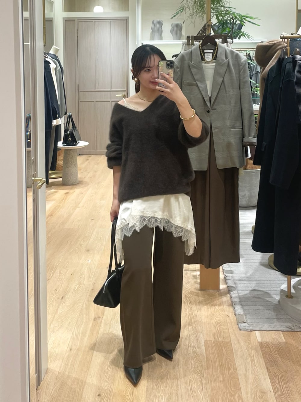 ブラウン系のニット/セーター、ホワイト系のキャミソール、ブラウン系のその他パンツを着用したレディースの冬コーディネートの1枚目の写真