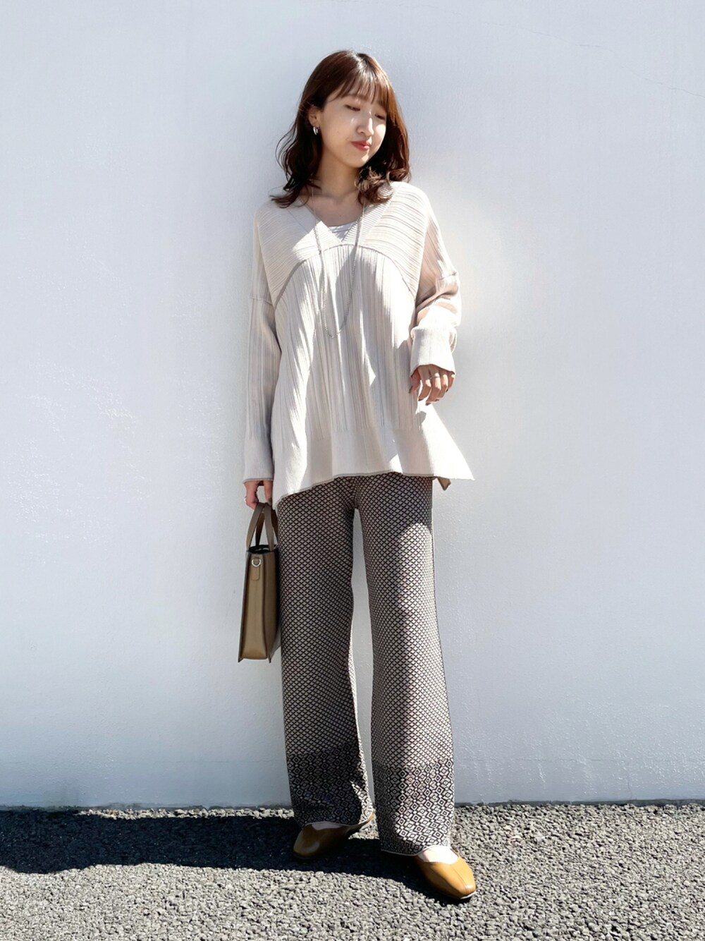 ホワイト系のニット/セーター、ブラック系のその他パンツ、グリーン系のショルダーバッグを着用したレディースの秋コーディネートの1枚目の写真