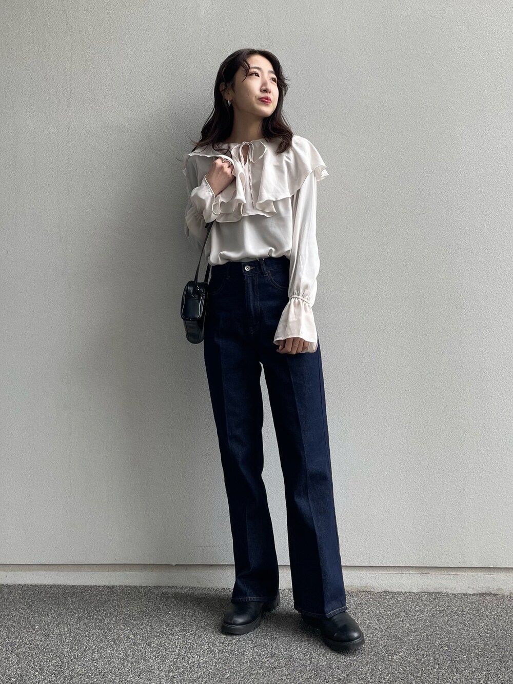 ホワイト系のシャツ/ブラウス、ブルー系のデニムパンツ、ブラック系のショルダーバッグを着用したレディースの冬コーディネートの1枚目の写真