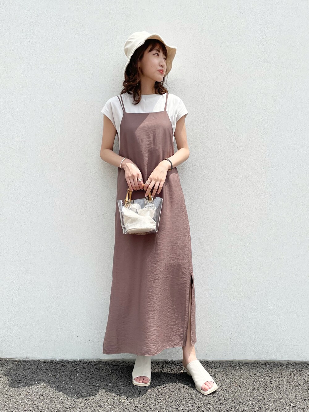 ベージュ系のワンピース、イエロー系のTシャツ/カットソー、ブラック系のサンダルを着用したレディースの夏コーディネートの1枚目の写真