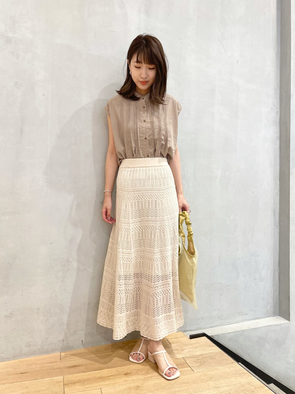 イエロー系のショルダーバッグ、グリーン系のシャツ/ブラウス、ホワイト系のその他シューズを着用したレディースの夏コーディネートの1枚目の写真