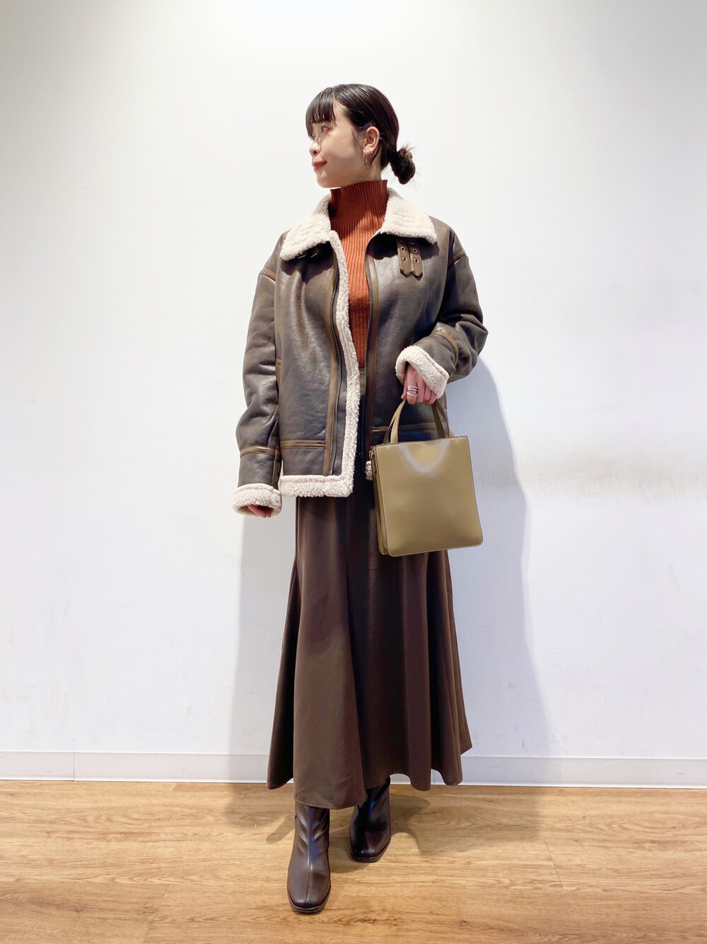 ブラウン系のスカート、ブラウン系のブルゾン、ブラウン系のブーツを着用したレディースの冬コーディネートの1枚目の写真