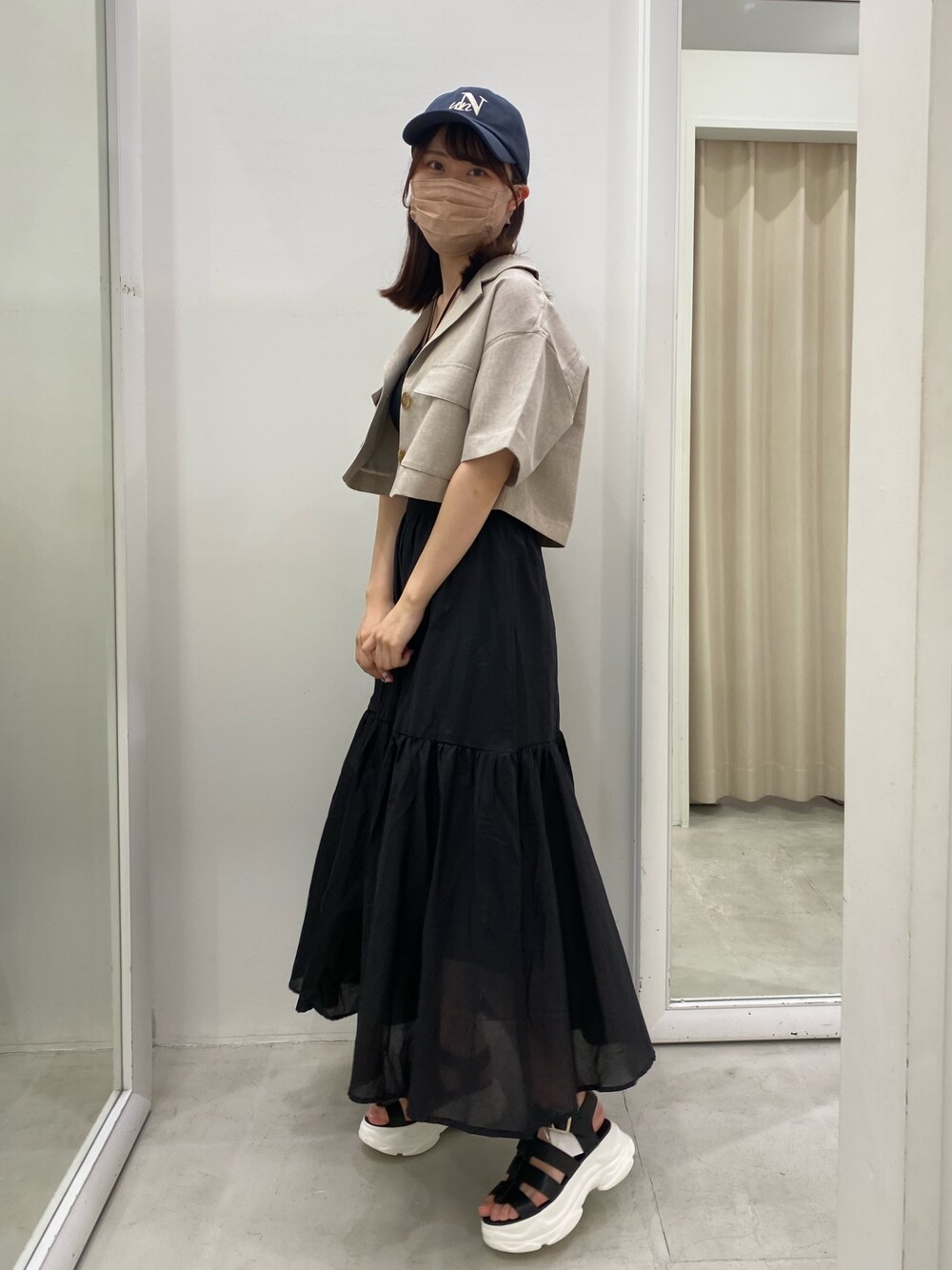 ブラック系のキャミソール、ホワイト系のテーラードジャケット、ブラック系のスカートを着用したレディースの夏コーディネートの1枚目の写真