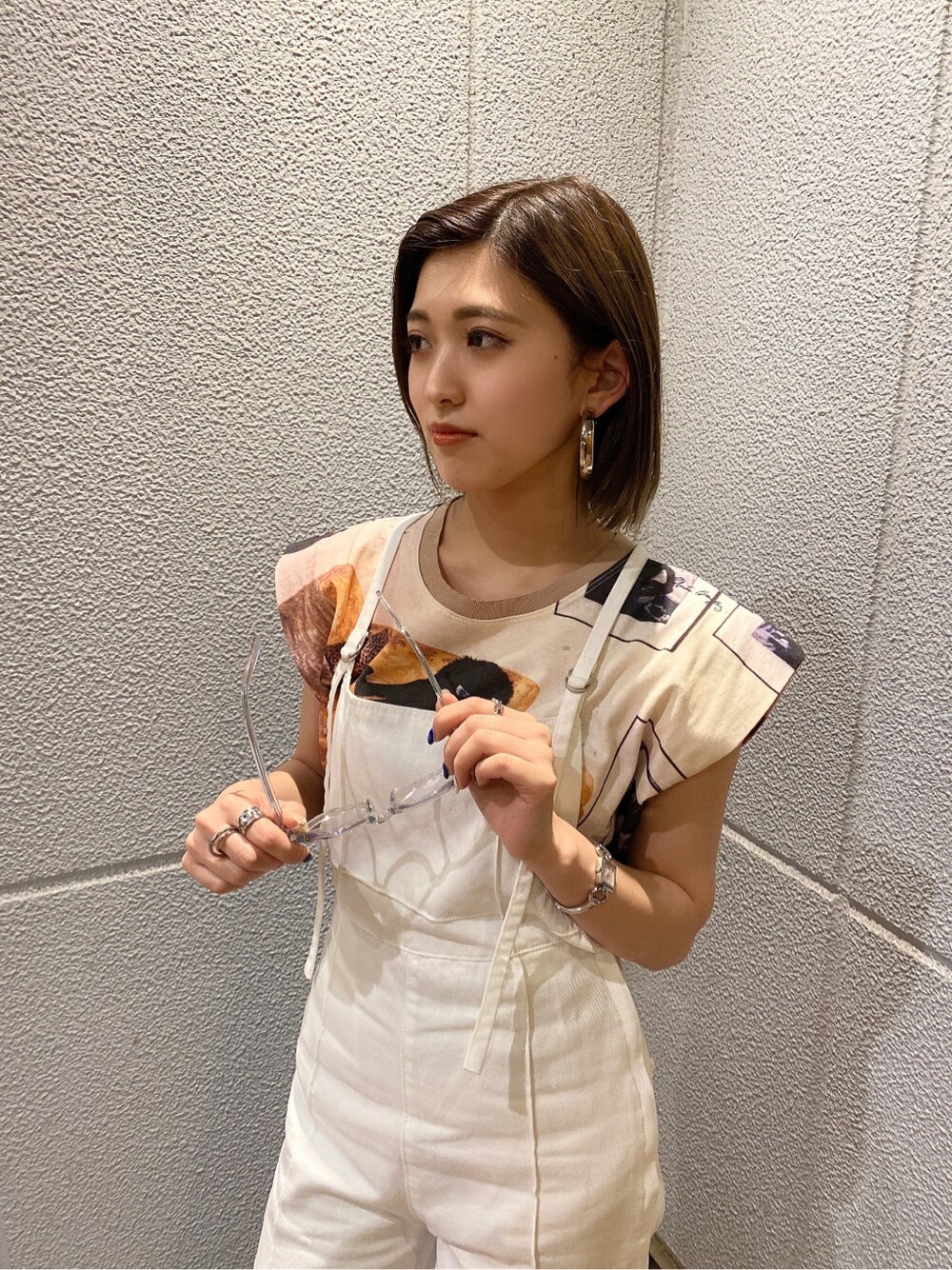 ホワイト系のサロペット/オーバーオール、ブラック系のサンダル、ベージュ系のTシャツ/カットソーを着用したレディースの夏コーディネートの1枚目の写真