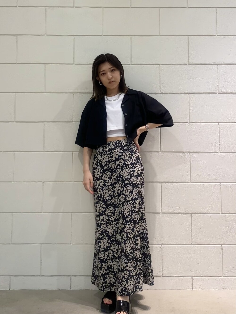 ブラック系のサンダル、ブラック系のシャツ/ブラウス、ホワイト系のTシャツ/カットソーを着用したレディースの春コーディネートの1枚目の写真