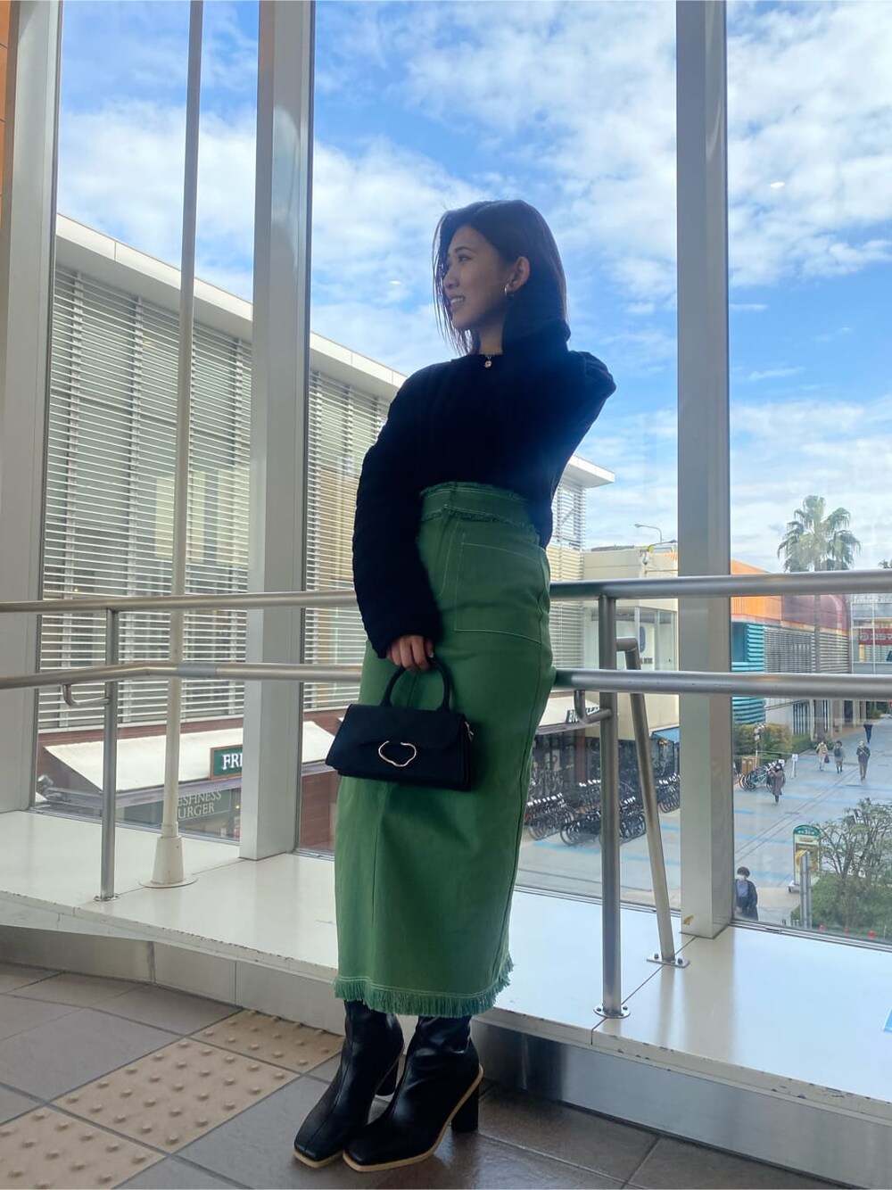 ブラック系のニット/セーター、ブラック系のブーツ、ブラック系のハンドバッグを着用したレディースの冬コーディネートの1枚目の写真