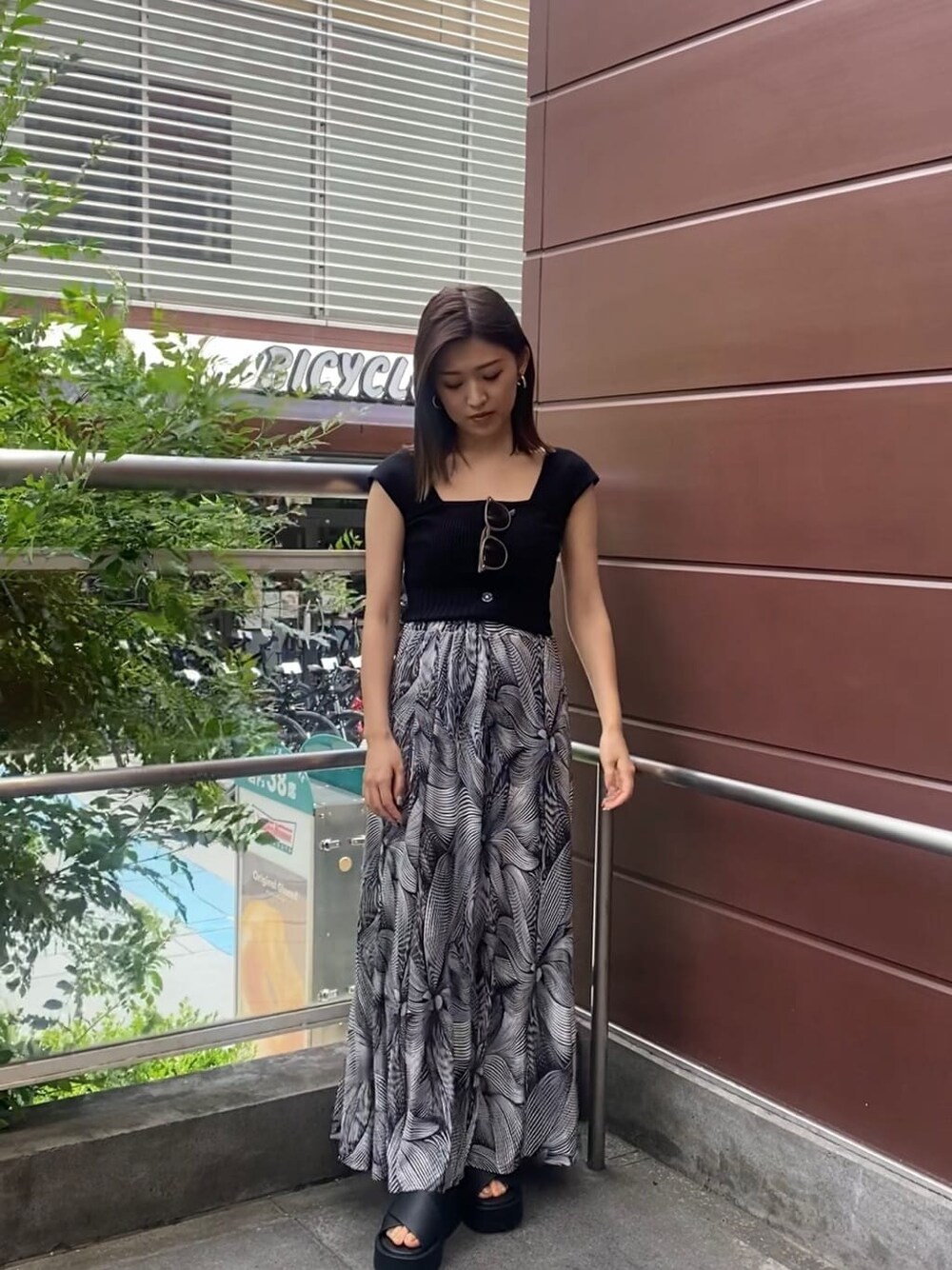 ブラック系のサンダル、ブラック系のタンクトップ、その他のスカートを着用したレディースの夏コーディネートの1枚目の写真