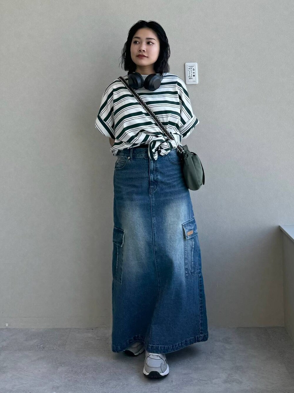 ブルー系のデニムスカート、グリーン系のショルダーバッグ、その他のTシャツ/カットソーを着用したレディースの春コーディネートの1枚目の写真