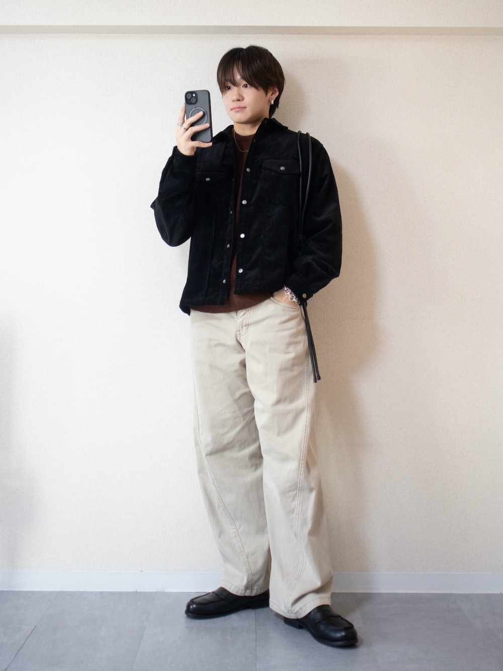 ベージュ系のデニムパンツ、ブラック系のシャツ/ブラウス、ブラウン系のニット/セーターを着用したメンズの冬コーディネートの1枚目の写真