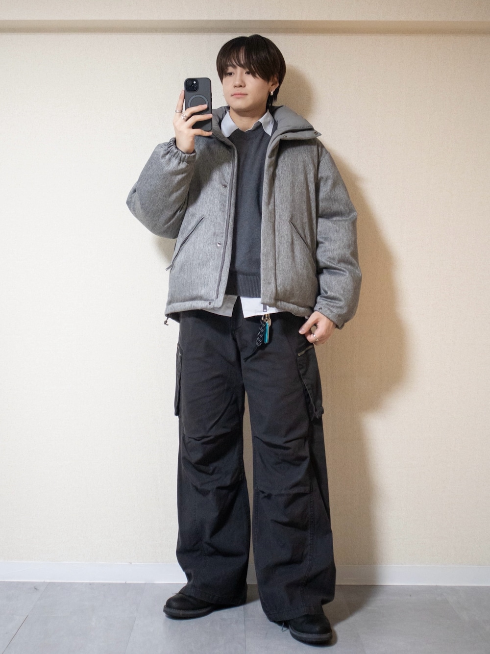 ブラック系のカーゴパンツ、グレー系のニット/セーター、グレー系のダウンジャケット/コートを着用したメンズの冬コーディネートの1枚目の写真