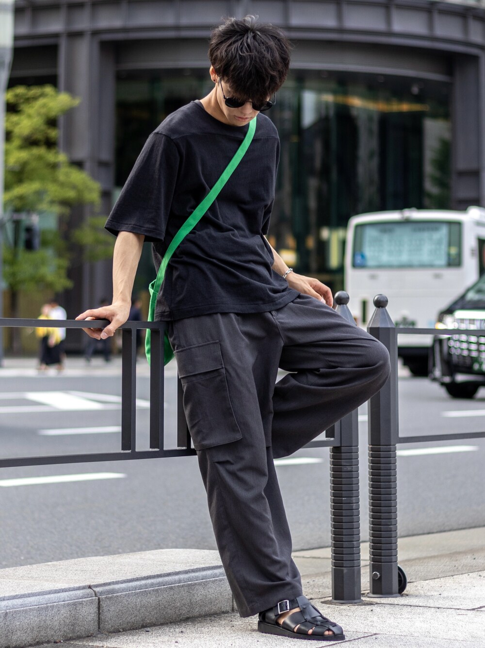 グレー系のカーゴパンツ、グリーン系のショルダーバッグ、ブラック系のサンダルを着用したメンズの夏コーディネートの1枚目の写真