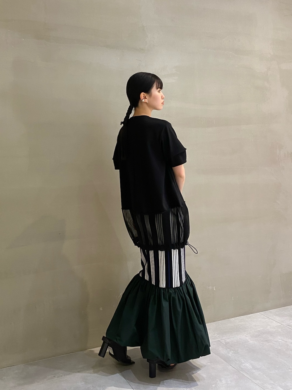 ブラック系のTシャツ/カットソー、ブラック系のサンダル、その他のスカートを着用したレディースの春コーディネートの1枚目の写真