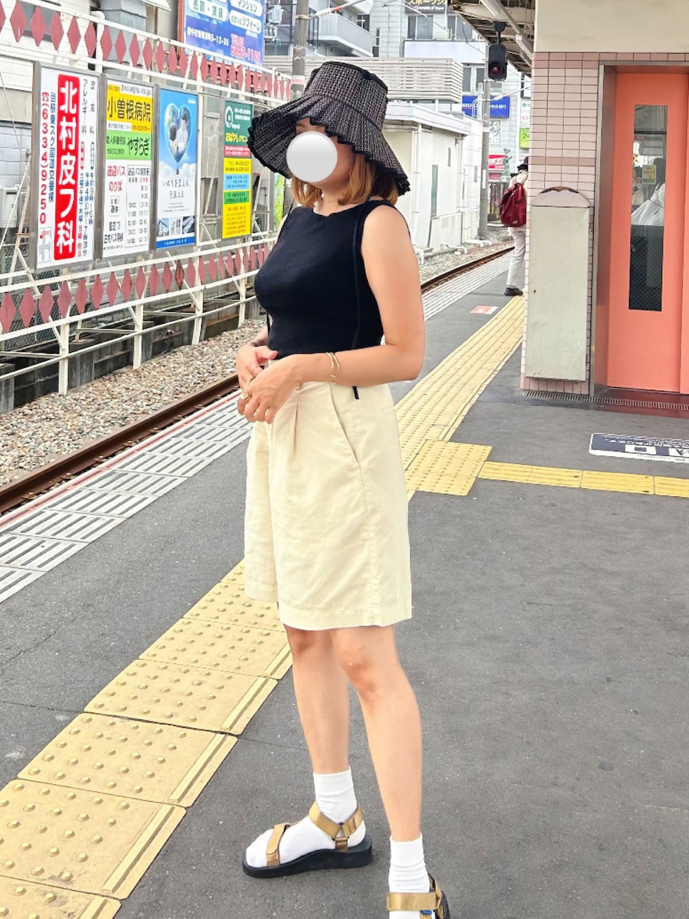 ブラック系のタンクトップ、ベージュ系のパンツ、ブラック系のハットを着用したレディースの夏コーディネートの1枚目の写真