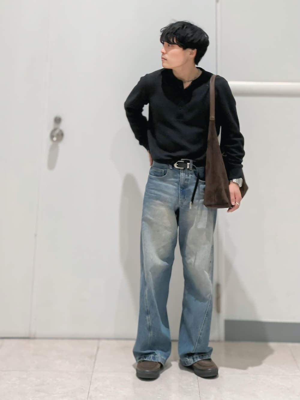 ブルー系のデニムパンツ、ブラウン系のショルダーバッグ、ブラウン系のスニーカーを着用したメンズの春コーディネートの1枚目の写真