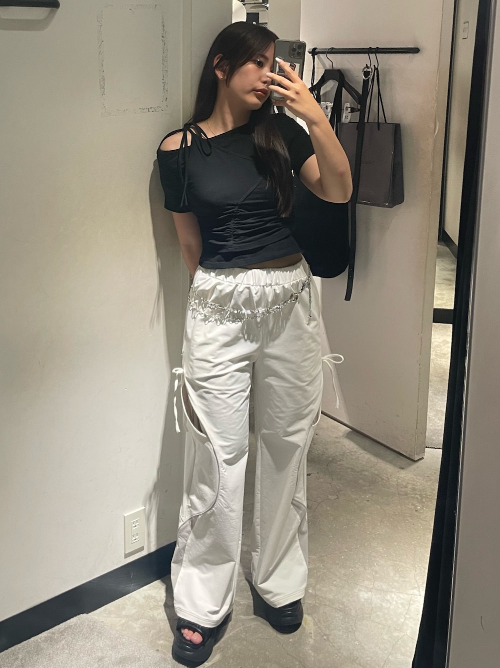 ブラック系のTシャツ/カットソー、ホワイト系のその他パンツ、ブラック系のサンダルを着用したレディースの春コーディネートの1枚目の写真