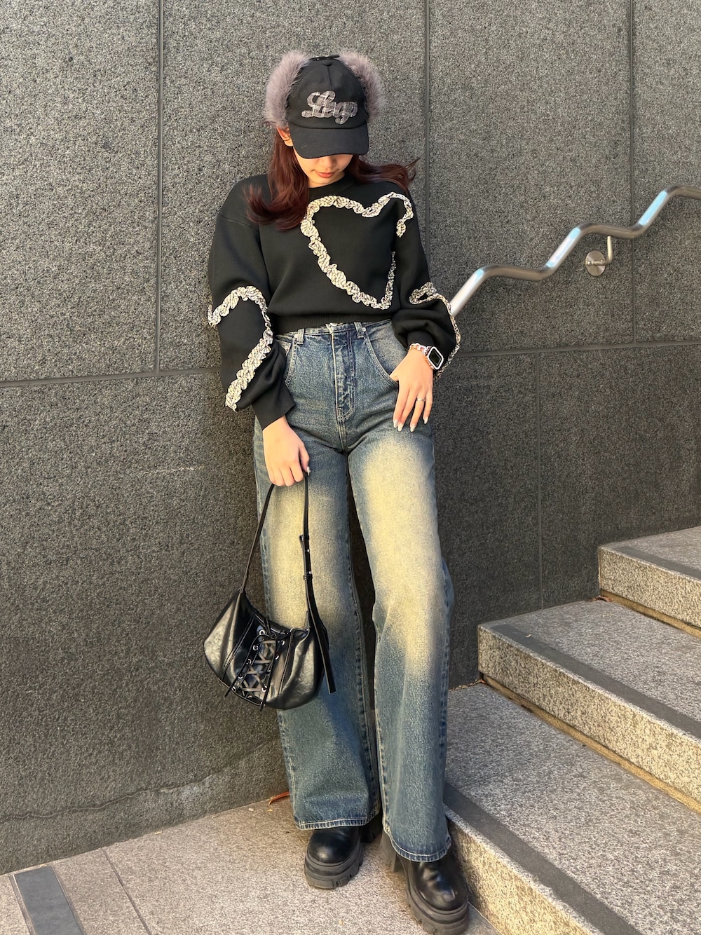 ブラック系のニット/セーター、ブルー系のデニムパンツ、ブラック系のショルダーバッグを着用したレディースの冬コーディネートの1枚目の写真