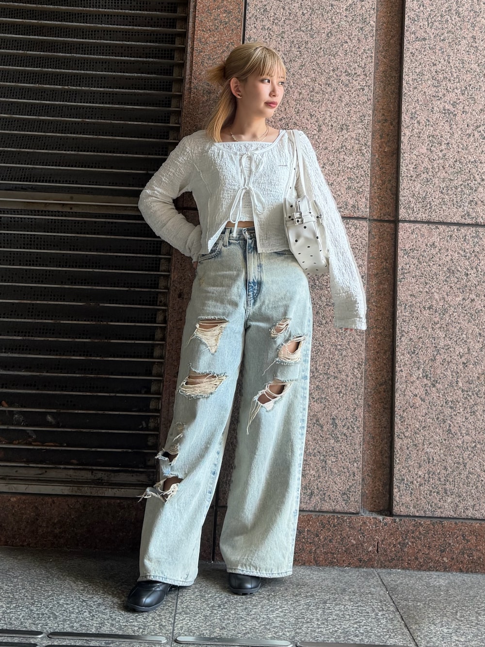 ホワイト系のTシャツ/カットソー、ブルー系のデニムパンツ、ホワイト系のショルダーバッグを着用したレディースの春コーディネートの1枚目の写真