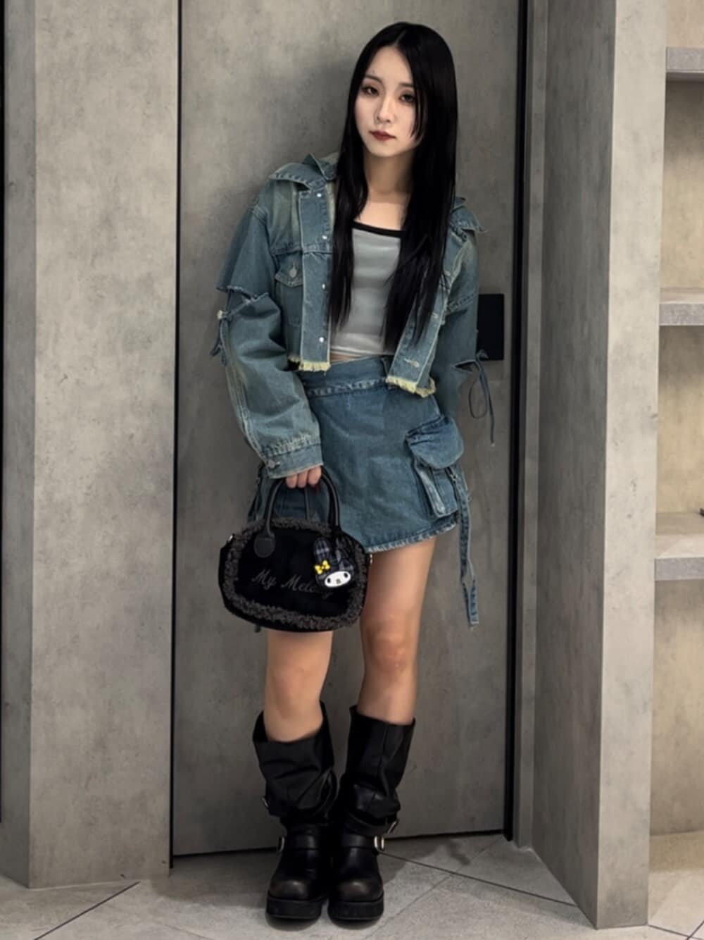 ブラック系のボストンバッグ、ブラック系のブーツ、ブルー系のデニムジャケットを着用したレディースの冬コーディネートの1枚目の写真