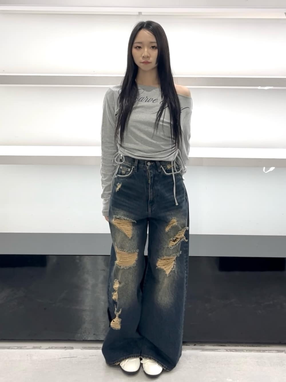 グレー系のTシャツ/カットソー、ブルー系のデニムパンツ、ホワイト系のスニーカーを着用したレディースの春コーディネートの1枚目の写真