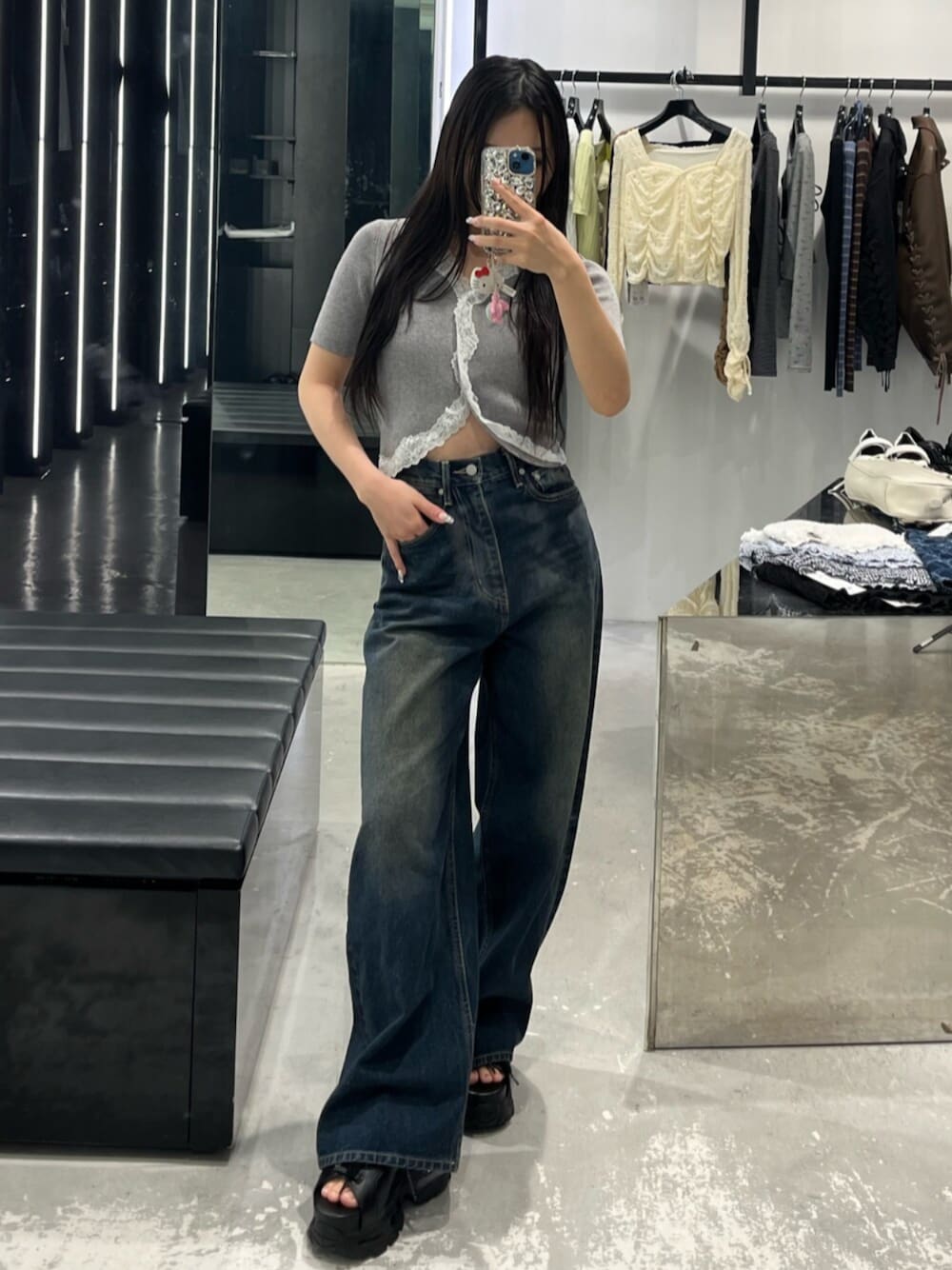 ブルー系のデニムパンツ、グレー系のニット/セーター、ブラック系のサンダルを着用したレディースの春コーディネートの1枚目の写真
