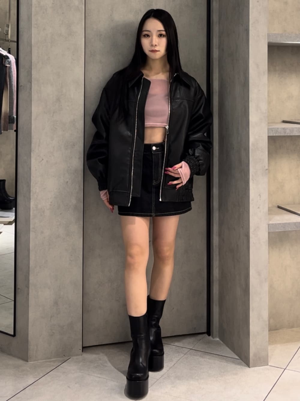 ブラック系のブルゾン、ピンク系のTシャツ/カットソー、ブルー系のスカートを着用したレディースの冬コーディネートの1枚目の写真